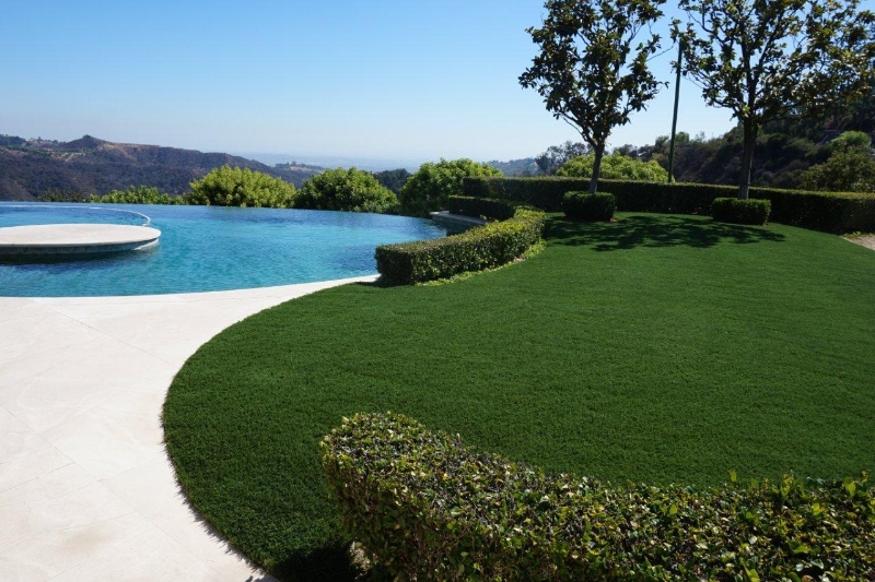Artificial turf installation close to a pool in a drought area.